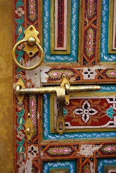 the door is decorated with colorful designs and gold handles, including an ornate keyhole