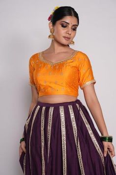 Purple lehenga in chanderi base with gota borders. Comes with orange embroidered blouse and maroon organza dupatta.
Component: 3
Pattern: Embroidered
Type Of Work: Gota Work, Floral Motifs
Neckline: Leaf
Sleeve Type: Half
Fabric: Lehenga and Blouse: Chanderi, Dupatta: Organza
Color: Purple
Other Details: 
Gota borders on lehenga
Back cut-out with tassel tie-up
Sequin and gota floral pattern on dupatta
Embroidered dupatta borders with fringed lace
Occasion: Wedding - Aza Fashions Orange Chanderi Set With Gota Work, Navratri Orange Choli With Cutdana, Navratri Orange Cutdana Choli, Orange Unstitched Blouse Sharara For Diwali, Orange Sharara With Unstitched Blouse For Diwali, Bollywood Style Orange Choli With Cutdana, Festive Orange Chanderi Choli, Orange Chanderi Choli For Festivals, Festive Orange Sharara With Unstitched Blouse