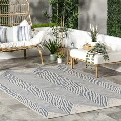 a living room with plants and rugs on the floor