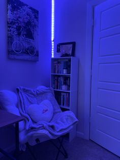 a room with a chair, book shelf and blue light