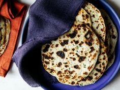 some tortillas are on a blue plate with a purple cloth next to it