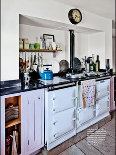 a kitchen with an old fashioned stove top oven and white cabinets is shown in this image