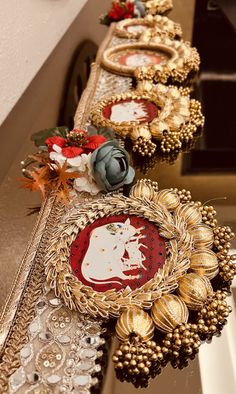 several decorative items are lined up on a counter top in a row with flowers and other decorations