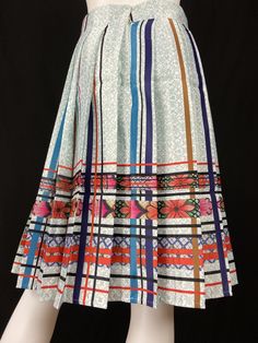 Mexican Fashion Pleated Skirt - Nayibi Mexico Talavera Skirt This elegant skirt is from the Talavera Collection inspired by the tiles of the region of Puebla where they began to make floors made of clay painted by hand taking as reference the Spanish pottery of which the Mexican appropriated this so-called “Talavera”. Lined Backed zipper *Pairs wonderfully with Talavera Top Care/Import Dry clean Import Contents 100% Polyester 100% Polyester Linning White Printed Long Skirt, Traditional Pleated Skirt For Spring, Traditional Multicolor Flared Skirt, Traditional Multicolor Flowy Skirt, Multicolor Skirt With Traditional Patterns, Retro Multicolor Pleated Skirt, Multicolor Full Gathered Skirt, Multicolor Lined Flared Pleated Skirt, Multicolor Gathered Full Skirt