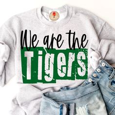 we are the tigers t - shirt with ripped jeans and sneakers next to each other