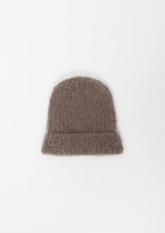 a brown knitted hat sitting on top of a white surface