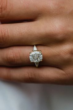 a woman's hand with a diamond ring on it