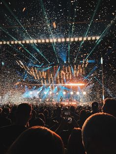 a large crowd at a concert with confetti in the air