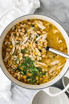 a white bowl filled with chicken and bean soup