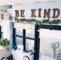 there is a sign that says be kind on the wall above the windows in this room