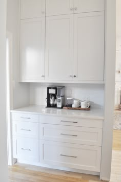 the kitchen is clean and ready to be used for breakfast or coffee time, with all white cabinets