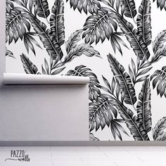 an artistic wallpaper design with black and white leaves on the wall in a room