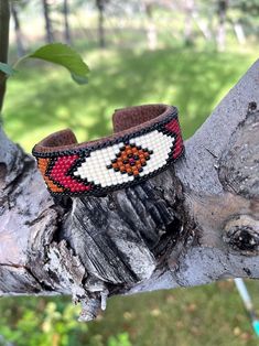 the beaded bracelet is sitting on top of a tree branch