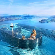 a woman and two dogs are sitting in the water on a floating platform that looks like a boat