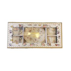 a boxed set of four tea cups and saucers in a floral pattern with gold trim