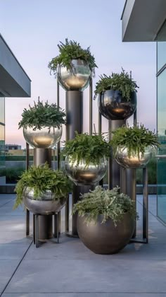 several metal planters with plants in them