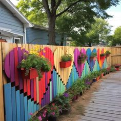 a colorful wooden fence with flower pots on it