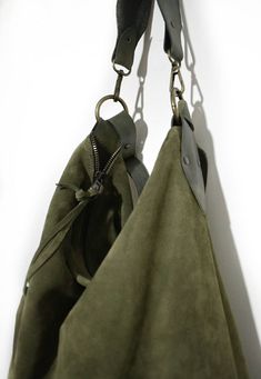 Handmade suede hobo bag make with olive green suede. This bag is unlined, inside there is a big cotton zipped pocket. The strap is make with stronger hand dyed leather and is adjustable between 21,65 inch and 43,30 inch. The has an amovable handle. The handle length is 15,64 inch. The bag is closed with a zip. This confortable hobo bag is very practical for any occasion. This bag is very large and soft and may contain many things. This bag is a sinlge piece Features : - Olive green suede, - hand Green Crossbody Hobo Bag With Zipper Closure, Green Leather Hobo Bag With Adjustable Strap, Green Leather Bags With Brass Hardware, Green Hobo Tote Bag With Zipper Closure, Green Leather Handled Crossbody Hobo Bag, Green Leather Hobo Shoulder Bag, Green Leather Handle Crossbody Hobo Bag, Suede Hobo Shoulder Bag With Zipper, Suede Hobo Shoulder Bag With Zipper Closure