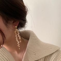 Introducing our exquisite Pearl Drop Earrings, a true masterpiece in asymmetrical elegance. These earrings are meticulously handcrafted using a combination of real freshwater pearls and 18 karat yellow gold vermeil. The unique wavy design, with its beige pearls and subtle, blurry details, evokes a sense of graceful fluidity. Embrace the artistry of asymmetry and add a touch of ethereal beauty to your style with these light white wonders. Gold Pearl Linear Earrings With Matching Pair, Gold Single Long Drop Pearl Earring, Elegant Gold-plated Earrings With Dangling Beads, Gold Long Drop Earrings With Pearl Pendant, Gold Long Drop Pearl Pendant Earrings, Elegant Gold Dangle Wrap Earrings, Black Friday Jewelry, Mens Stainless Steel Rings, Freshwater Pearl Earrings