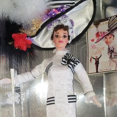 a barbie doll wearing a white dress and hat with feathers on it's head