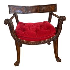 an antique chair with a red cushion on it