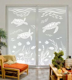 a living room with sliding glass doors that have sea animals etched on them