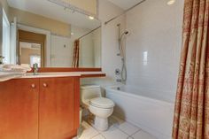 a bathroom with a sink, toilet and bathtub next to a shower curtain in it