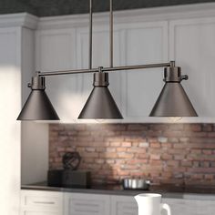 a kitchen island with three lights hanging from it's side and a brick wall in the background