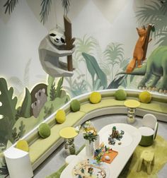 the children's room is decorated in green and yellow tones with stuffed animals on the wall