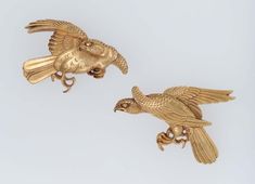 two gold bird figurines sitting on top of each other