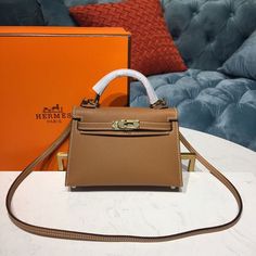 Description HRMS Mini Kelly Gold For Women Gold Toned Hardware 7.5in/19cm Rep 1:1 Measurements: 19 x 6 x 13 cm / 7.5 x 2.4 x 5 inches (Length x Width x Height) Hermès bags are considered the ultimate luxury item worldwide. Each piece is handcrafted with waitlists that can exceed a year or more. The streamlined and demure Kelly style is always in high demand, it is particularly lovely in this vibrant version with silver hardware. Epsom is textured with a wonderful grainy appearance. Epsom is soft to the hand and maintains the shape of the bag well over time, the most popular choice for Kelly. Warm gold hardware is the perfect complement to this vivid pop color. Gold-toned hardware Interior with 1 side zippered pocket A protective footed bottom Adjustable shoulder strap Includes box, dust ba Mini Kelly, Gold For Women, Togo Leather, Birkin 25, Luxury Products, Orange Leather, Mini Crossbody Bag, Evening Clutch Bag