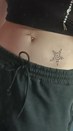 a woman's stomach with an arrow tattoo on it