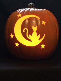 a carved pumpkin with a cat sitting on it's side and stars in the middle