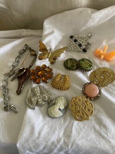 lot of 17 vintage junk drawer scrap items to make jewelry or crafts with.  lot includes 5 rusty keys hanging on a ring, plastic tiny baby, brass butterfly, gold plated horseshoe looking concho piece, flat silver plated cross angel wing concho, two rusty bottle caps,  hard plastic cameo, flat gold plated swirl with tarnishing and paint loss, topaz stoned brooch with broken hardware, scarf clip, big silver plated piece with rhinestones and black stones and a single pink earring spot on front Vintage Charms For Crafting Jewelry, Pink Earring, Vintage Junk, Crafts Jewelry, Junk Drawer, Le Lot, Topaz Stone, Pink Earrings, Jewelry Inspo