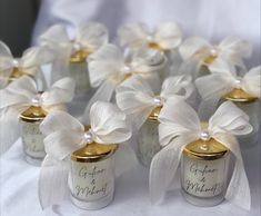 small jars with white bows and labels on them