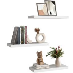 two white shelves with books, vases and other decorative items on top of them