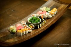 sushi is arranged on a wooden platter and ready to be served for consumption