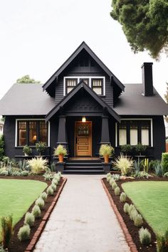 a black and white house with plants in front