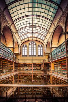 the inside of a large library with lots of bookshelves and windows in it