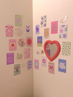 there is a heart shaped mirror on the wall next to some cards and magnets