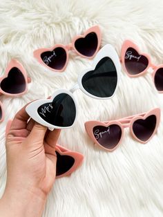 someone is holding up some heart shaped sunglasses