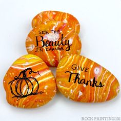 four painted rocks with words on them saying, see the beauty in orange give thanks