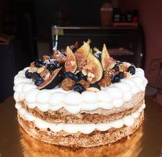 there is a cake that has figs and nuts on it with white frosting