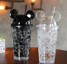 two mickey mouse cups sitting on top of a table