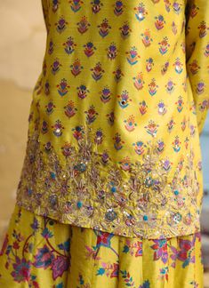 Editor's Note Bask in the brilliance of our sunshine yellow printed dupion silk kurta, elevated by hand-embroidered detailing. This ensemble exudes charm and sophistication. Paired harmoniously with printed kali pants, it's a perfect fusion of style and comfort, making it an exquisite choice for any occasion. Fabric: Dupion silk, net Color: Yellow Components: Kurta and sharara Occasion: Festive Disclaimer: Product color may slightly vary due to photographic lighting sources or your monitor setti Yellow Kurta, Blouse Yoke, Short Kurta, Silk Kurta, Dupion Silk, Sunshine Yellow, Yellow Shorts, Yellow Print, Floral Print Shorts