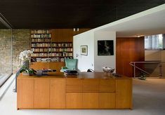 an office area with bookshelves, desk and stairs leading up to the second floor