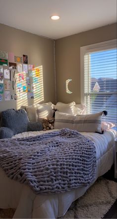 a bedroom with a bed, pillows and pictures on the wall