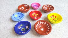 six small bowls with designs on them sitting on a counter top next to each other