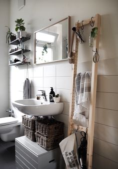 a bathroom with a toilet, sink and shelves on the wall next to each other