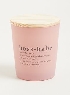 a pink candle with the words boss - babe on it sitting next to a white background